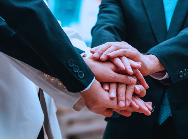 Business professionals joining hands in teamwork.